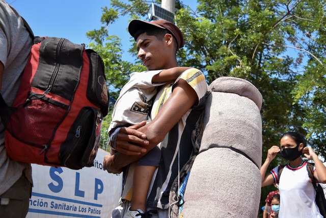 Migrantes caminan con sus hijos y maleta al hombro intentando pasar la frontera